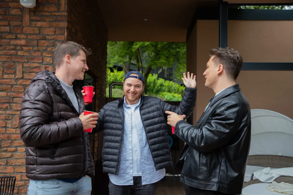 Three guests talking over drinks on a terrace