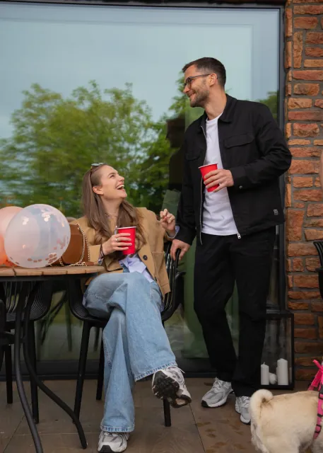 A guest seated at a table while another stands nearby