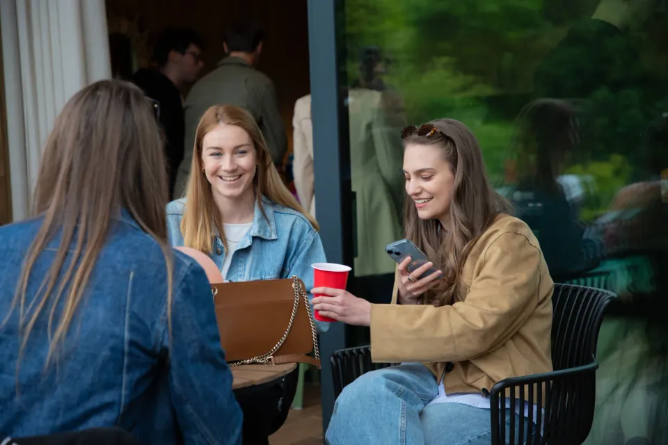 Three guests looking at a phone together