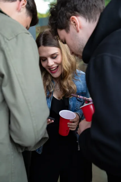 A guest laughing with the group, drink in hand